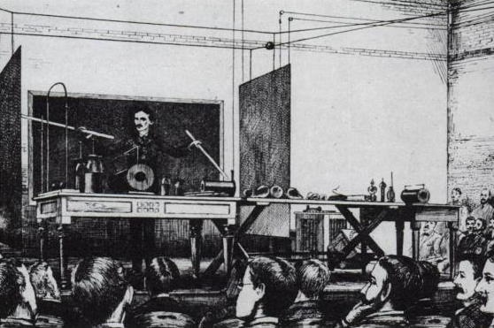 Tesla demonstrating wireless lighting by "electrostatic induction" during an 1891 lecture at Columbia College via two long Geissler tubes (similar to neon tubes) in his hands.