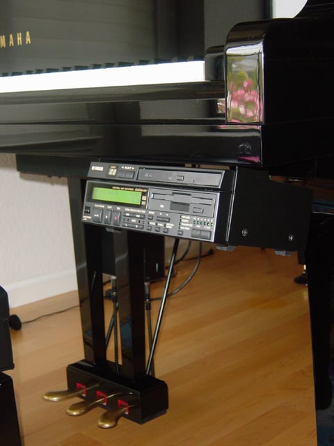 The Yamaha Disklavier player piano. The unit mounted under the keyboard of the piano can play MIDI or audio software on its CD or floppy disk drive.