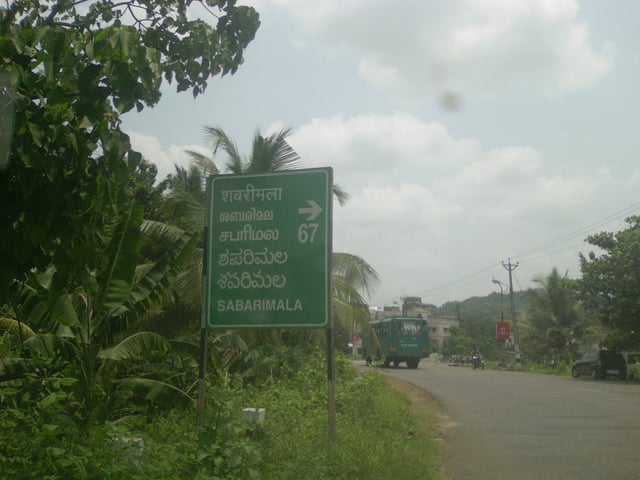A sign-board that indicates the direction to Sabarimala. The multilingual board is written in English, Hindi, Malayalam, Tamil, Telugu and Kannad