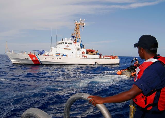 A boatswain's mate watches from the side port door as the Coast Guard Cutter Bertholf's Over-The-Horizon small boat departs to receive personnel from the Coast Guard Cutter Chandeleur in 2008.