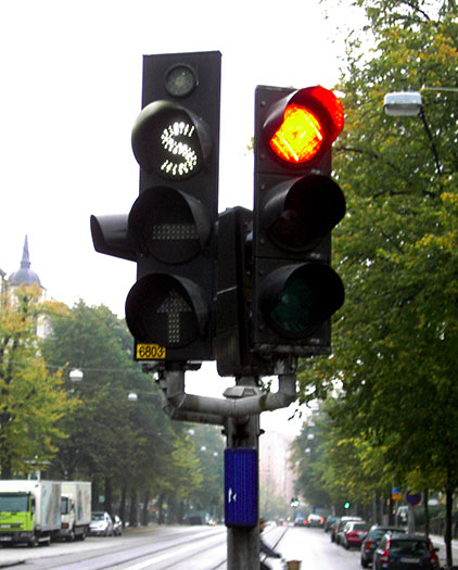 Swedish traffic light (left) for use by public transport vehicles only. All signals use white lighting and special symbols ("S", "–" and an arrow) to distinguish them from regular signals. The small light at the top tells the driver when the vehicle's transponder signal is received by the traffic light.