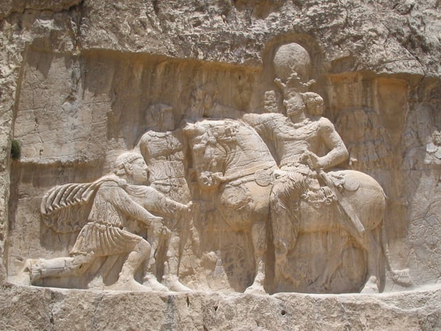 Rock-face relief at Naqsh-e Rustam of Persian emperor Shapur I (on horseback) capturing Roman emperor Valerian (standing) and Philip the Arab (kneeling), suing for peace, following the victory at Edessa.