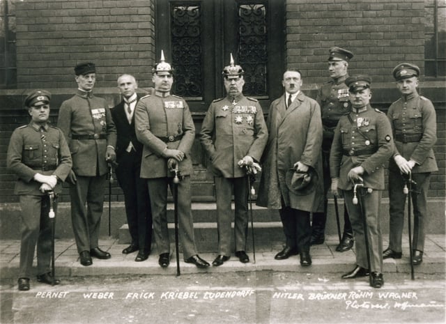 1 April 1924. Defendants in the Beer Hall Putsch trial. From left to right: Pernet, Weber, Frick, Kriebel, Ludendorff, Hitler, Bruckner, Röhm, and Wagner. Note that only two of the defendants (Hitler and Frick) were wearing civilian clothes. All those in uniform are carrying swords, indicating officer and/or aristocratic status