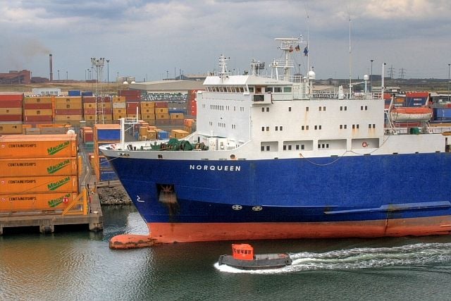 A tug passes M/V Norqueen at Teesport, which operates the freight-only RORO route to Rotterdam.