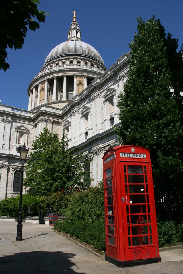 A red telephone box in front of St Paul's Cathedral, one of the most important buildings of the English Baroque period