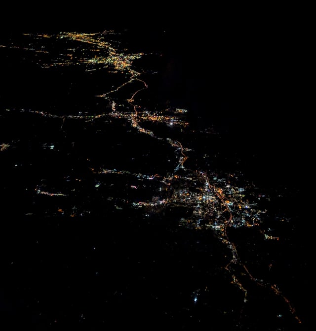 Night aerial view of Stamford from the west, with Norwalk, Bridgeport, and New Haven behind to the northeast. The dark area in the upper right is the Long Island Sound.
