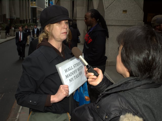 A protester on Wall Street in the wake of the AIG bonus payments controversy is interviewed by news media.