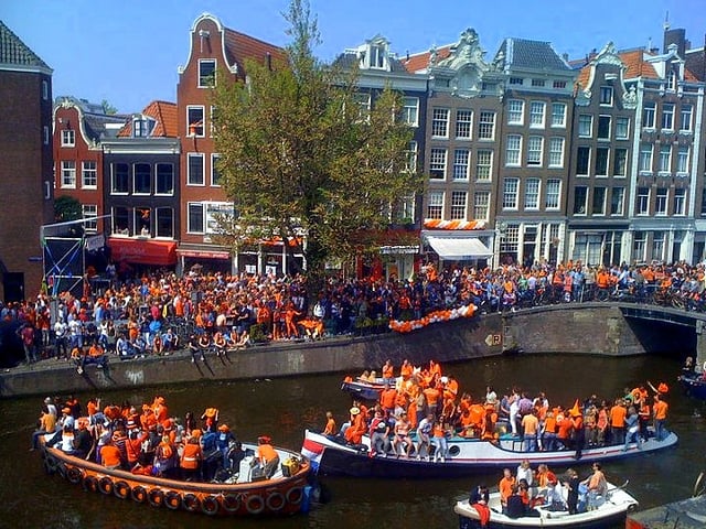 People dressed in orange on the canals of Amsterdam in 2010 during Koningsdag or King's Day.