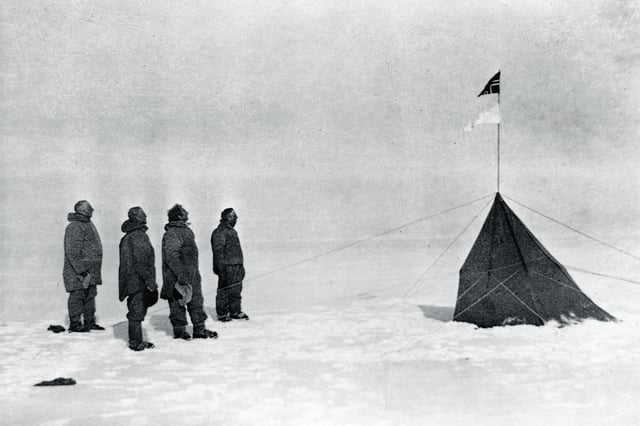 Roald Amundsen and his crew looking at the Norwegian flag at the South Pole, 1911