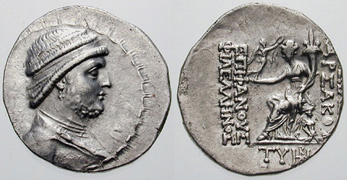 Drachma of Mithridates II of Parthia (r. c. 124–90 BC). Reverse side: goddess Tyche/Khvarenah holding a small Nike offering a wreath; inscription reading [ΒΑΣΙΛΕΩΣ] ΑΡΣΑΚΟΥ ΕΠΙΦΑΝΟΥΣ ΦΙΛΕΛΛΗΝΟΣ "of Renowned/Manifest [King] Arsaces the Philhellene.