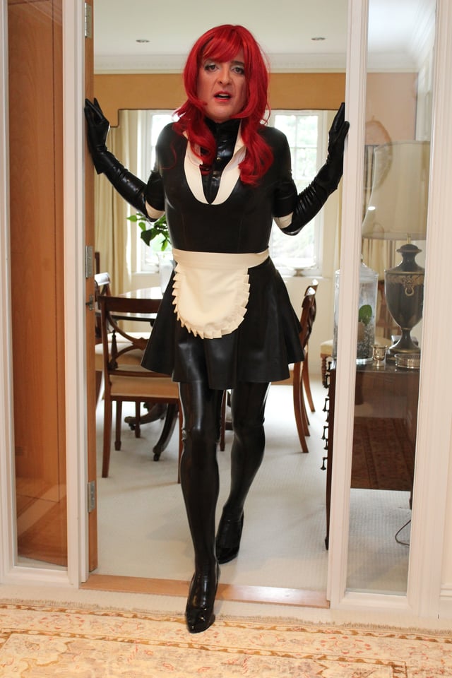 A feminized male wearing a latex maid's uniform