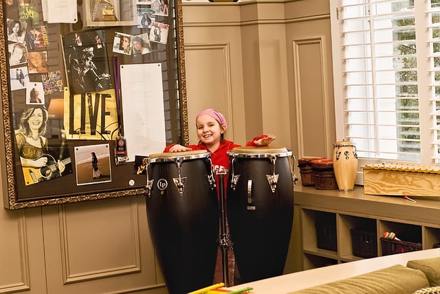 A child playing congas in the Amy Grant Music Room at St. Jude Children's Research Hospital
