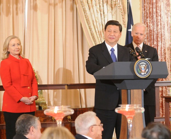 Xi giving a speech at the U.S. Department of State in 2012, with then Secretary of State Hillary Clinton and then Vice-President Joe Biden in the background. Seated in the front row is former Secretary of State Henry Kissinger.