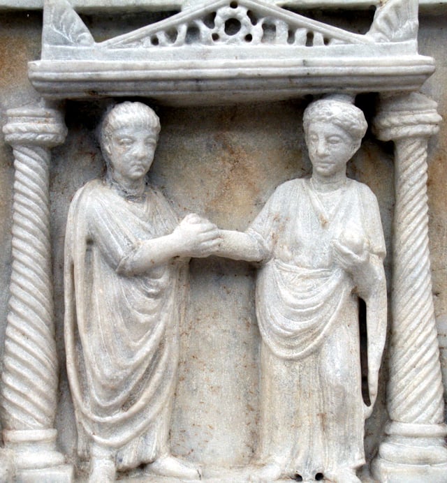 Couple clasping hands in marriage, idealized by Romans as the building block of society and as a partnership of companions who work together to produce and rear children, manage everyday affairs, lead exemplary lives, and enjoy affection