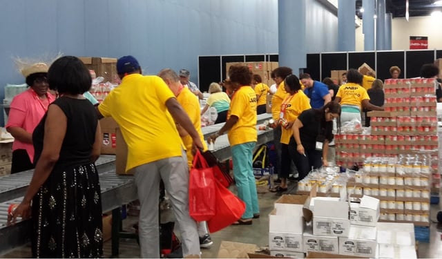 AARP volunteers packing food for older Americans in need at a packing event in Miami