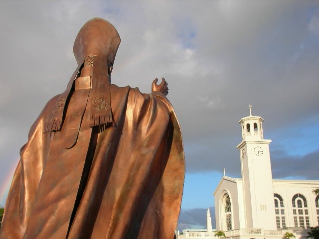 Dulce Nombre de Maria Cathedral Basilica in Hagåtña, faced by a statue of Pope John Paul II.