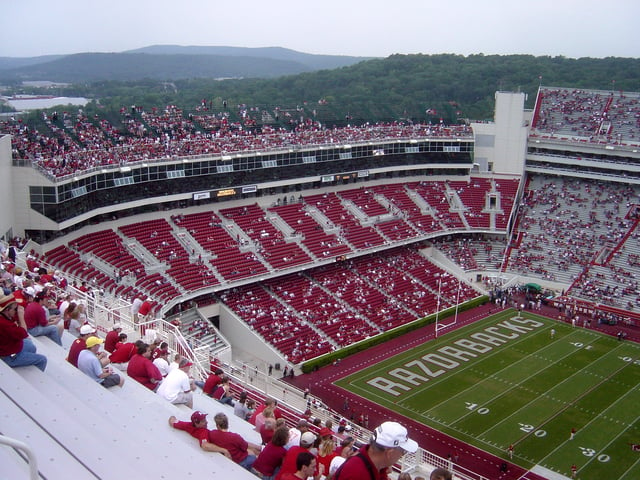 Donald W. Reynolds Razorback Stadium, home of the Arkansas Razorbacks football team, with The Ozarks visible beyond.