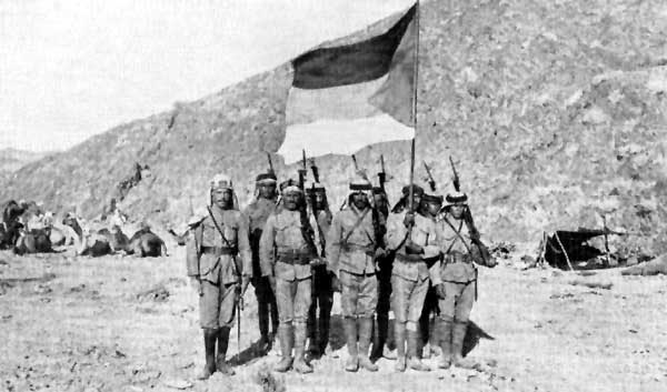 Soldiers of the Arab Army in the Arabian Desert carrying the Flag of the Arab Revolt