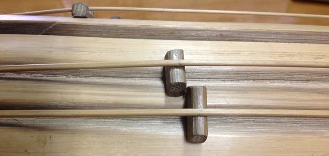A Kolitong's wooden frets. The frets are moved along the length of the string to adjust the string's pitch.