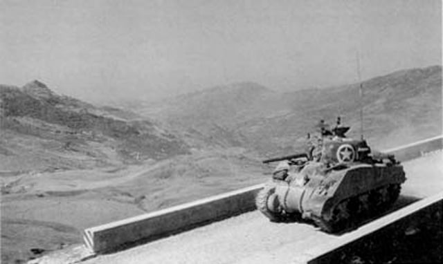 A U.S. Army Sherman tank moves past Sicily's rugged terrain in mid July 1943.