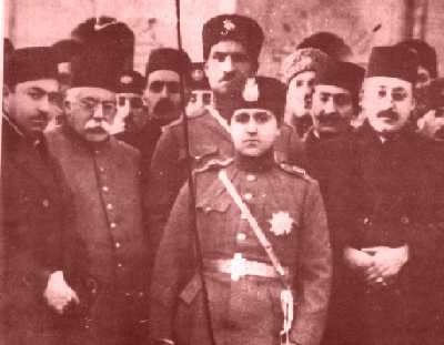 Reza Khan behind Ahmad Shah Qajar, with Abdol-Hossein Farman Farma to the left of Reza Khan.