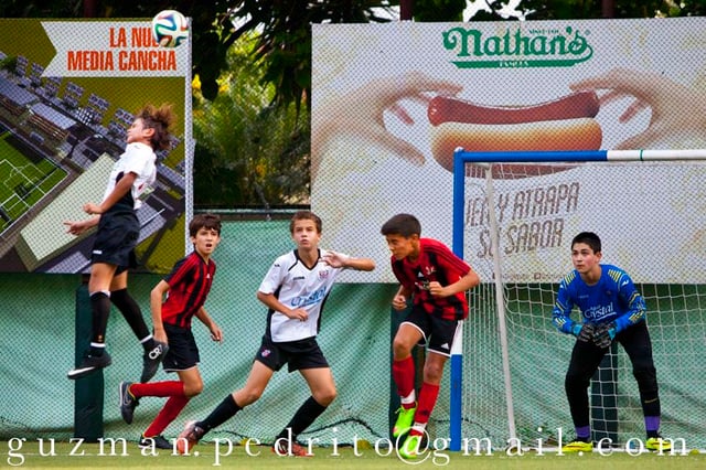 Young boys playing association football in the Santo Domingo's middle-class neighborhood of Altos de Arroyo Hondo.