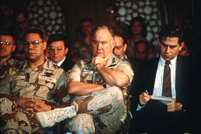 Gen. Colin Powell (left), Gen. Norman Schwarzkopf, Jr., and Paul Wolfowitz (right) listen as Secretary of Defense Dick Cheney addresses reporters regarding the 1991 Gulf War.