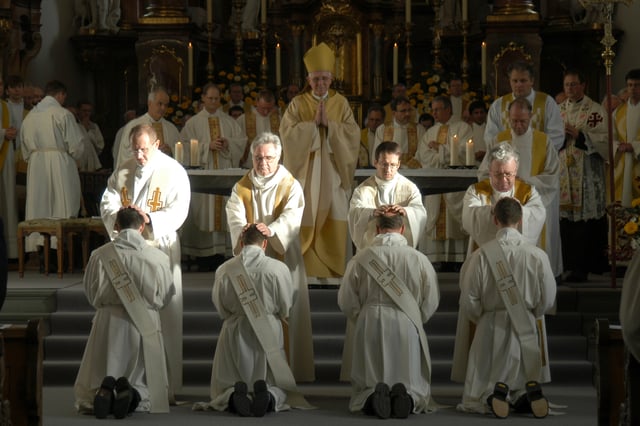 During the rite of ordination, after the bishop the priests present lay their hands on the ordinands