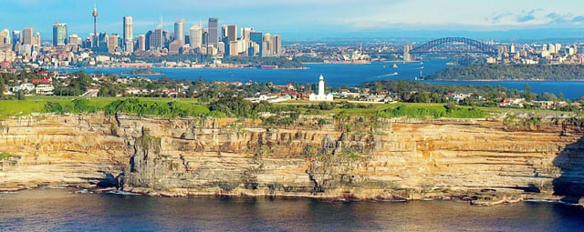 Sydney skyline as viewed from Tasman Sea, overlooking the clifftop suburb of Vaucluse.