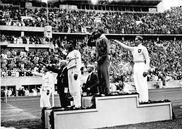 Jesse Owens on the podium after winning the long jump at the 1936 Summer Olympics