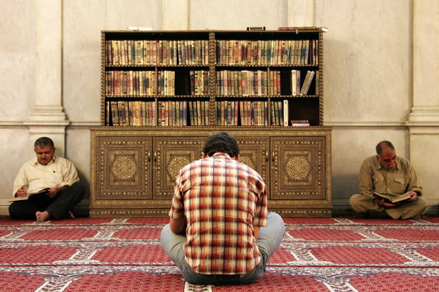 Muslim men reading the Quran