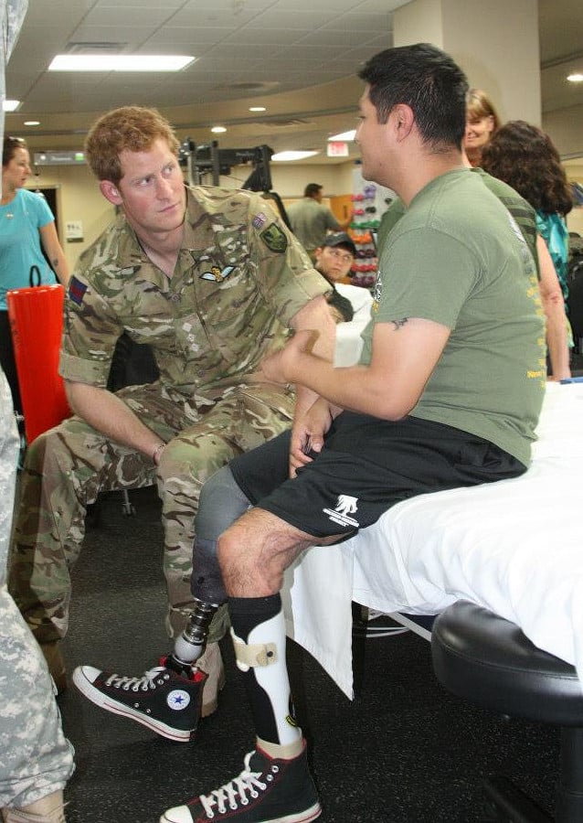 Harry (left) talking to an injured soldier at the Walter Reed National Military Medical Center, 15 May 2013