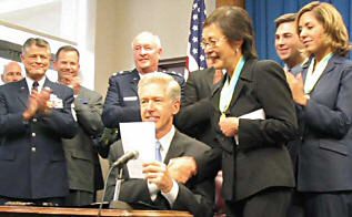Davis signs AB 574 on September 11, 2003, establishing a student loan repayment program for members of the State Military Forces.