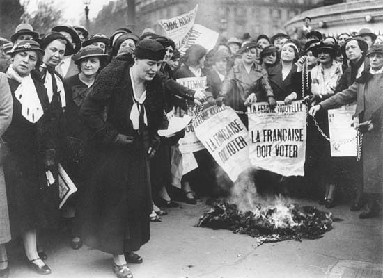 Louise Weiss along with other Parisian suffragettes in 1935. The newspaper headline reads "The Frenchwoman Must Vote."