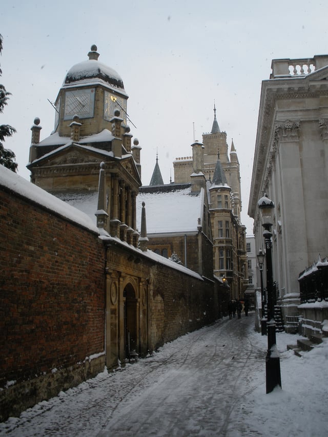 Senate House Passage in the snow with Senate House on the right and Gonville and Caius College on the left