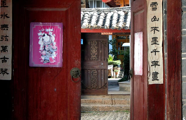 Hand-written Chinese New Year's poetry pasted on the sides of doors leading to people's homes, Lijiang, Yunnan