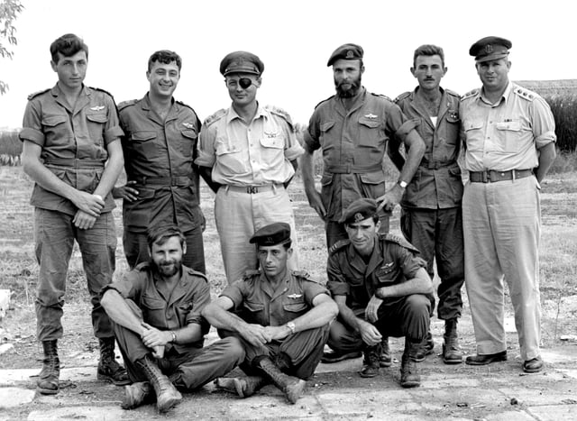 Israeli officers of the Paratrooper Battalion 890 in 1955 with Moshe Dayan (standing, third from the left). Ariel Sharon is standing, second from the left and commando Meir Har Zion is standing furthest left.