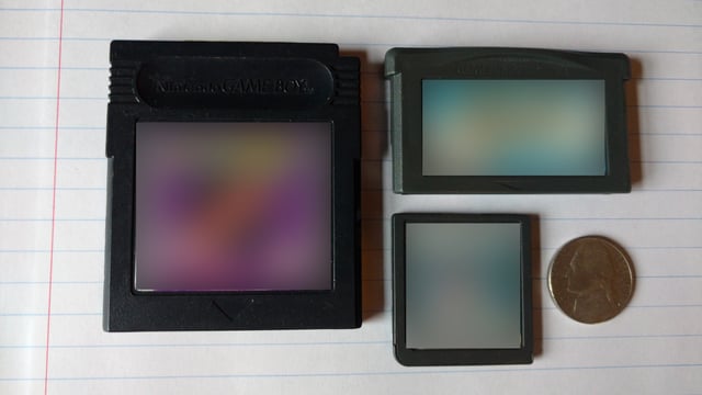 Clockwise from left: A Game Boy Color game cartridge, a Game Boy Advance game cartridge, and a Nintendo DS game cartridge. On the far right is a United States Nickel shown for scale.