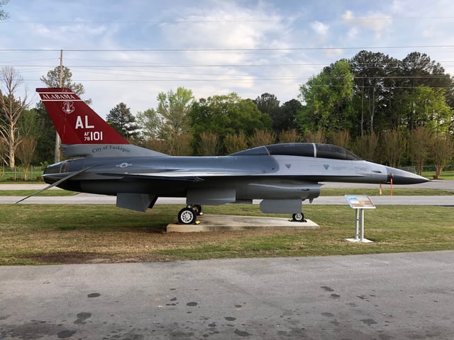 An F-16B on display at the Aviation Challenge campus of the U.S. Space & Rocket Center in Huntsville, AL; dorsal fin has an acknowledgment to Tuskegee Airmen.