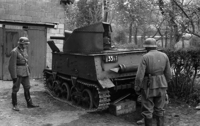 An abandoned Belgian T-13 tank destroyer is inspected by German soldiers.