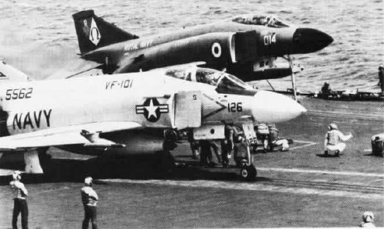 An F-4J of the U.S. Navy (foreground), alongside an F-4K of the Fleet Air Arm (background) wait to be catapulted from USS Independence, March 1975; one of the major differences can be seen by the higher degree of the British aircraft's extendable nose wheel. Both variants were eventually used by the RAF