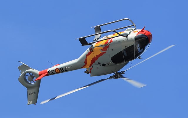 A Eurocopter EC120 helicopter demonstrates its agility with a barrel roll