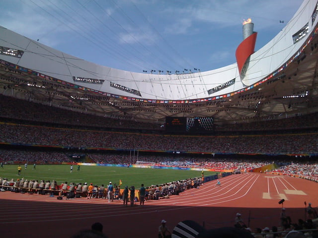 Inside Beijing National Stadium during the Games. Olympic cauldron in background.
