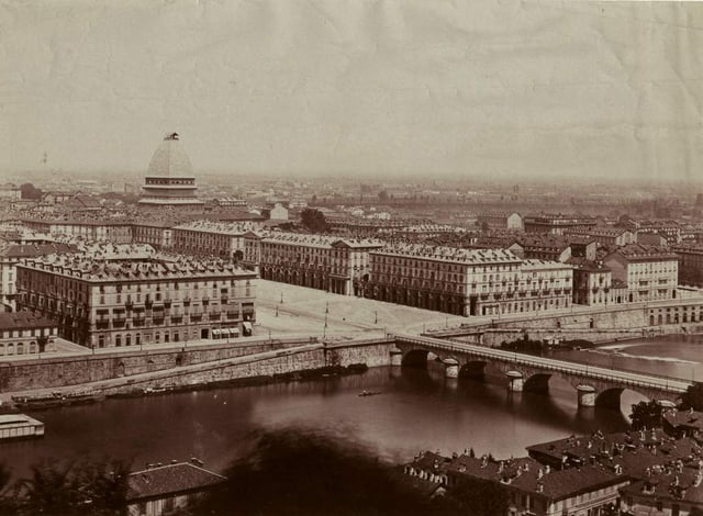 A view of Turin in the late 19th century. In the background, the Mole Antonelliana under construction.
