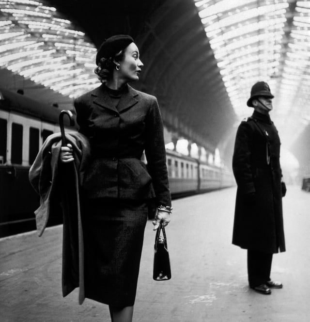 Lisa Fonssagrives in a tailored suit that features a long pencil skirt and a fitted jacket with peplum. Photograph by Toni Frissell for Harper's Bazaar, London, 1951