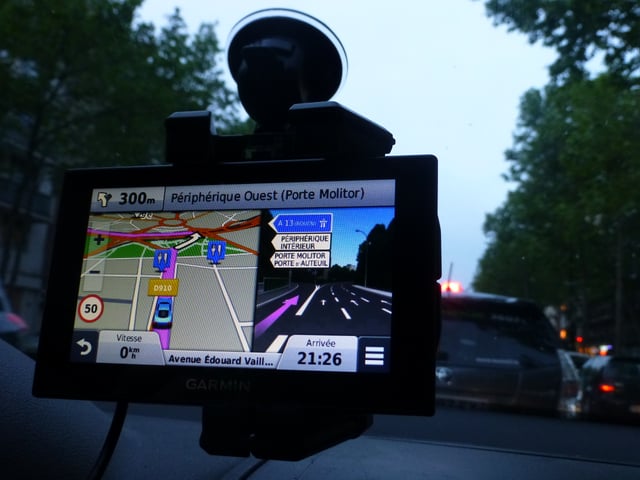 A personal navigation assistant GPS receiver in a car, which can give driving directions to a destination.