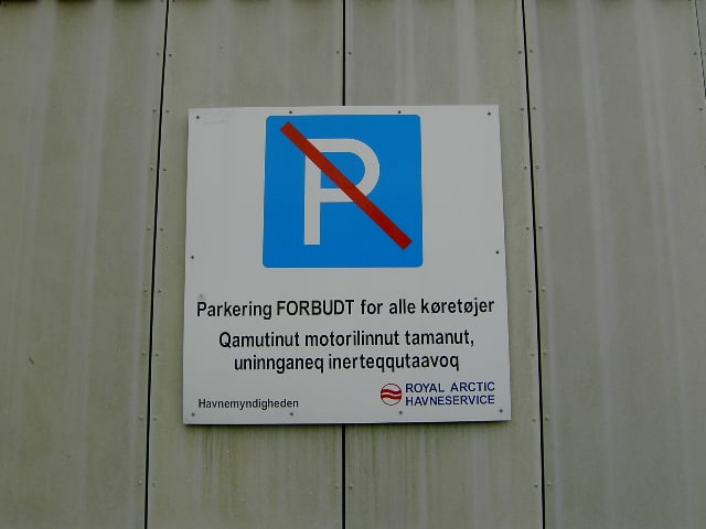 A bilingual sign in Nuuk, displaying the Danish and Kalaallisut for "Parking forbidden for all vehicles"