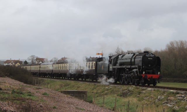 A steam locomotive and carriages, on the West Somerset Railway, a heritage line of notable length, in spring 2015
