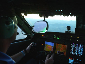 The cockpit of NASA's Gulfstream GV with a synthetic vision system display. The HUD combiner is in front of the pilot (with a projector mounted above it). This combiner uses a curved surface to focus the image.