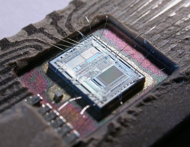 The die from an Intel 8742, an 8-bit microcontroller that includes a CPU running at 12 MHz, 128 bytes of RAM, 2048 bytes of EPROM, and I/O in the same chip